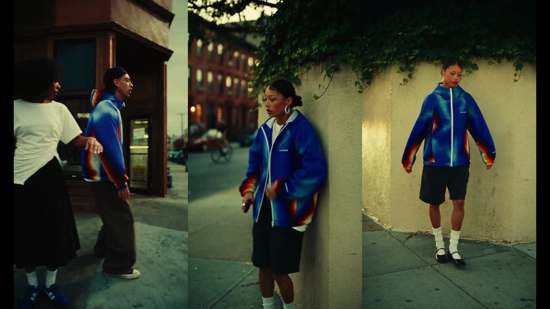 A woman pulls the hood of a blue Mertra jacket with flame-coloured sleeves over her head and looks straight into the camera in Jerry Oriadé's spec fashion film