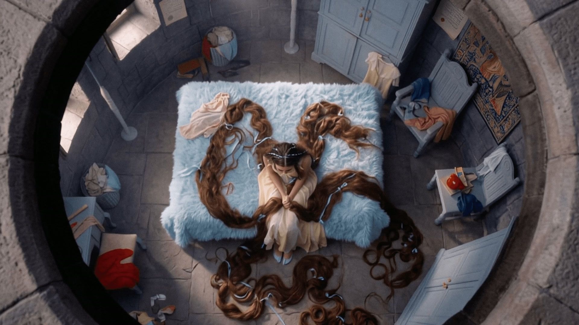 Rapunzel sits inside her tower room surrounded by long coils of hair.